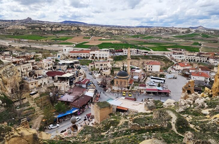 Kapadokya’nın tarihi yerleşimlerinden Çavuşin Köyü’nün yukarıdan görünümü; cami, taş evler ve vadi manzarasıyla birlikte